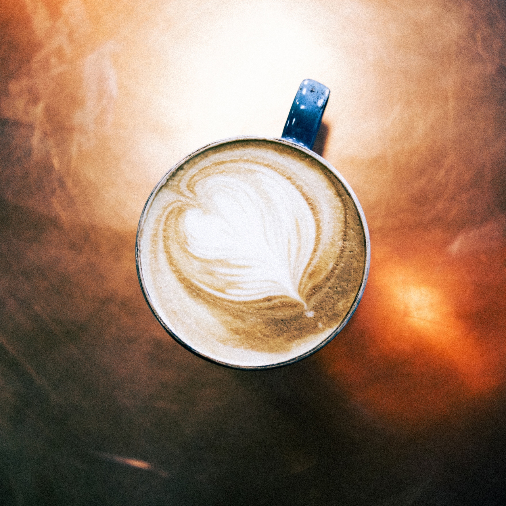arial view of a flat white coffee on a copper table top